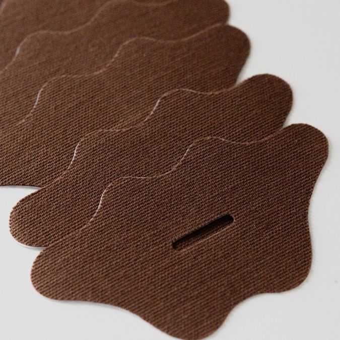 Brown fabric patches with a central cutout on a white background