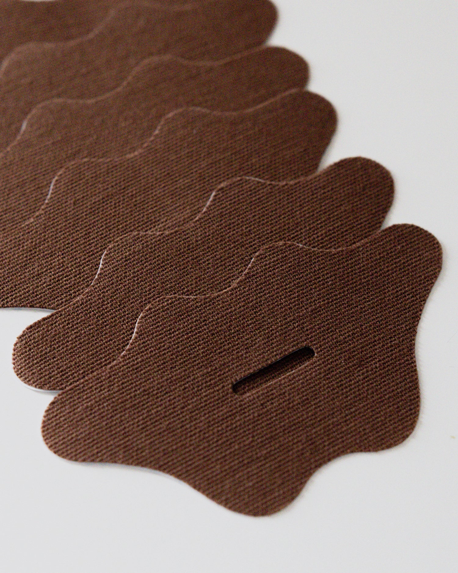 Close-up of brown Wellpa mouth tape strips with lip-shaped design for comfortable nighttime use