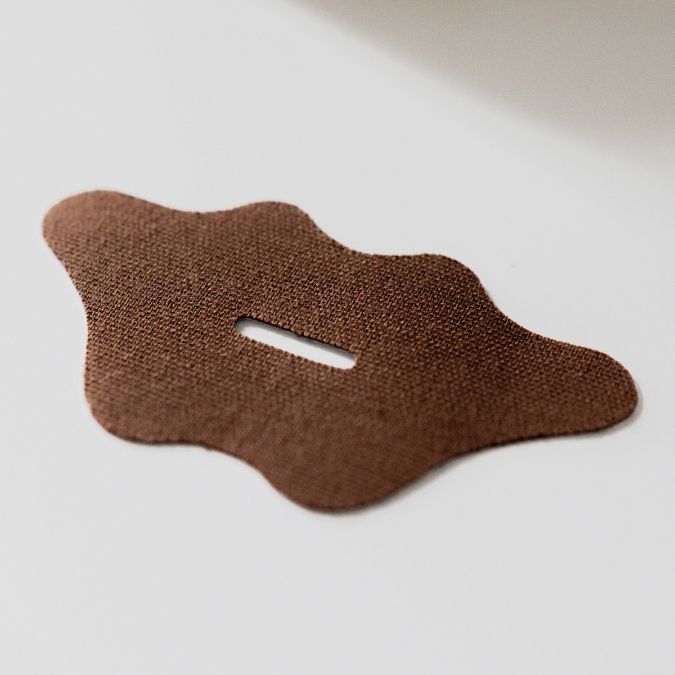 Brown textured patch with a central cutout on a light gray background